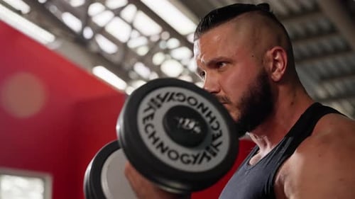 Muscular Man Lifting Dumbbell During Intense Gym Workout