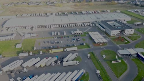 Logistics park with a warehouse and loading hub. Semi-trucks with cargo trailers standing at the ram