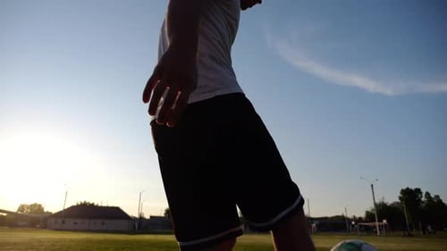 Legs of Young Man Kicking Ball at Green Field Male Feet of Professional Footballer Juggling Soccer