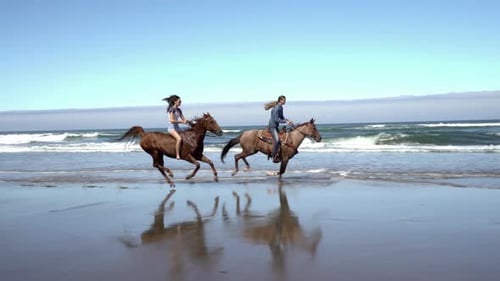 Two women enjoying a horseback ride on a beautiful summer beach