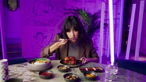 a beautiful young girl in a Korean restaurant is happy to try traditional dishes with an taste