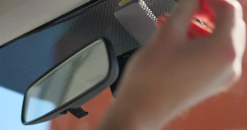 Hands attaching cables to front camera car recorder attached to windscreen