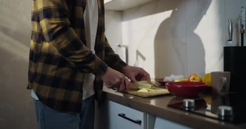 Man Cuts Apples in Bright Kitchen