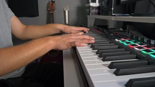 Musician Playing Keyboard in Home Studio