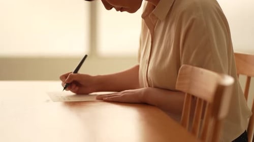 Adult Writing Card on Wooden Table