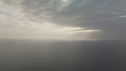 Eine Panorama-Luftaufnahme des ruhigen Mittelmeers unter bewölktem Himmel und weitem Horizont.