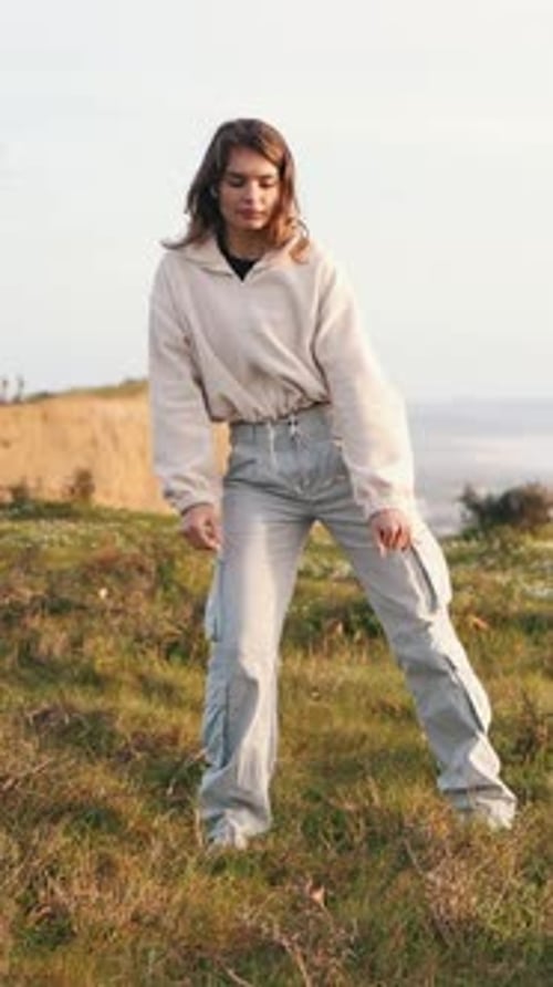Young Woman Dancing Freestyle on a Hilltop Meadow