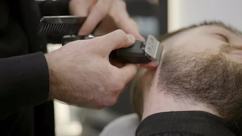 Barber Trimming Beard with Razor and Comb