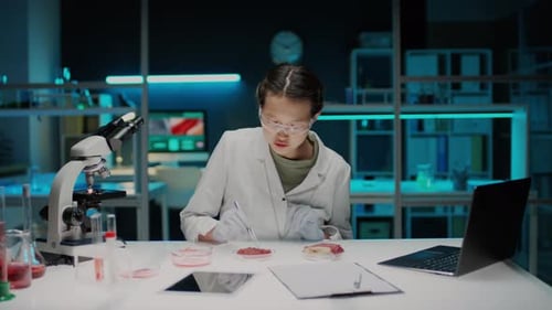 Scientist Analyzing Cultured Meat Sample in Bright Lab