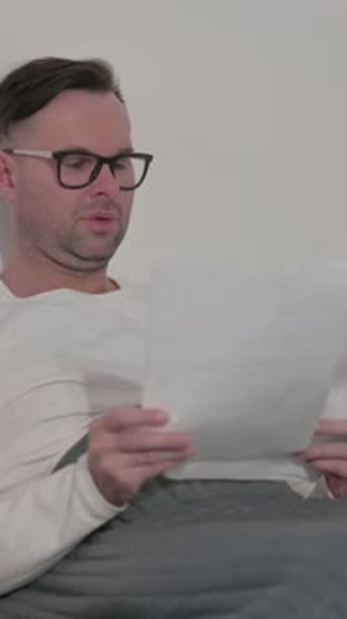 Man Reading Shocking News in Bed