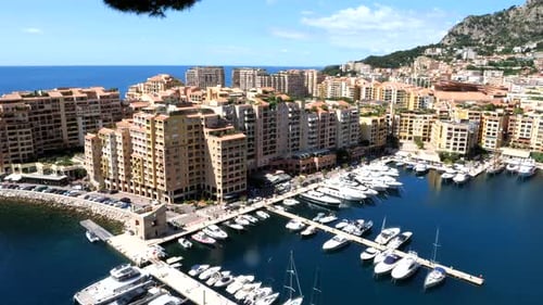Aerial panning shot of housing area with luxury Apartment and parking yachts in harbor. Monaco Ville