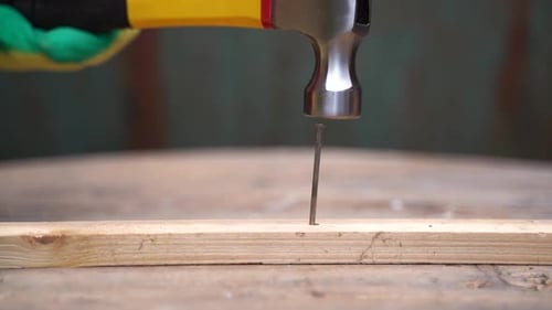 Hammering a Nail on Wood Close Up
