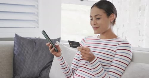 Woman Using Smartphone, Holding Credit Card Indoors