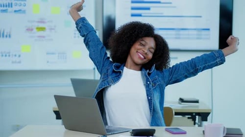 Smiling Woman Typing on Laptop in Modern Office