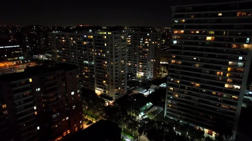 Complex of residential buildings at night on a quiet street with little traffic