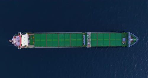 An Aerial View of a Green Cargo Ship Anchored at Sea