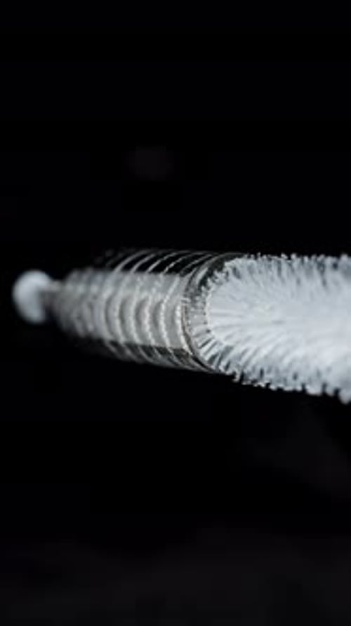 Vertical video. The brush for cleaning straws with a flexible metal handle enters the inside.