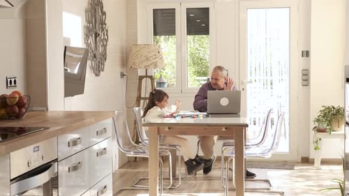 Man and Child Drawing Together at Home in Sunlight