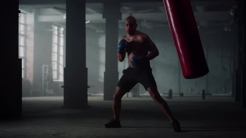 African American Man Punching Bag in Sport Club. Aggressive Boxer Boxing In