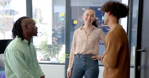 Collaborating in office, three colleagues discussing project ideas and strategies