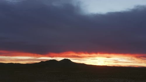 The harsh Mojave Desert climate and rugged landscape in silhouette as the sun rises - aerial view