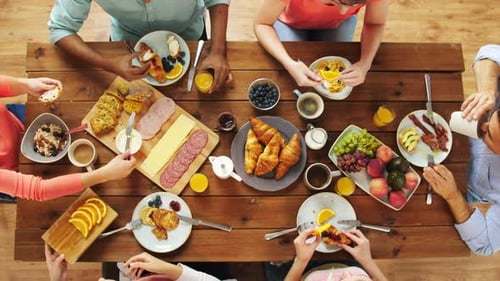 Overhead shot of friends enjoying breakfast together at table