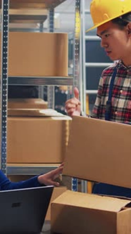 Warehouse Worker Stacking Boxes in Storage Area