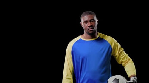 Goleiro masculino se estendendo, puxando a bola para dentro, relaxando a postura enquanto aperta a câmera para esportes