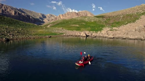 Kayakers Paddling Red Kayak on Mountain Lake