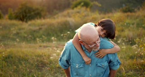 Grandson and Granfather Spending Time Together on Summer Meadow