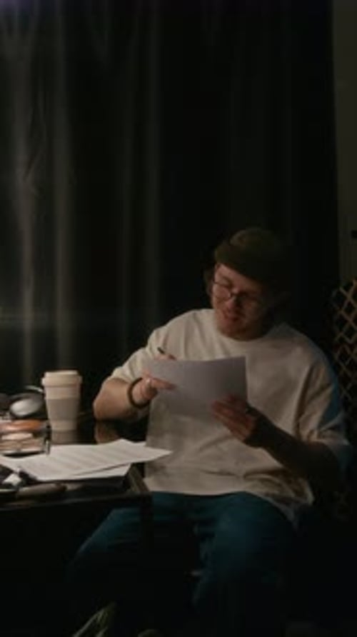 Man Rereading and Making Notes on Paper in his Stand-Up Performance Script