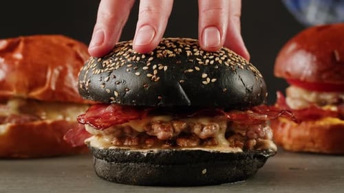 American Fat Smash Burger with Fresh Tomatoes Acon Slices Fried Onion and Cheese on Grill Closeup