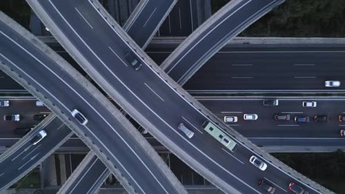 Top Down Zoom Out Aerial View of Highway Interchange with Traffic and Overpass Bridges At Evening