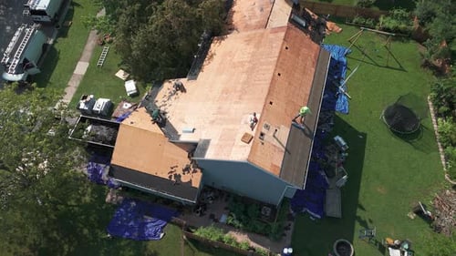 Roofers Installing a New Roof on an Building Wide Drone Shot View