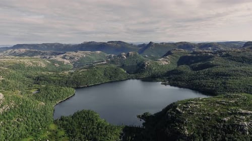Aerial View Flying Over a Pristine Lake and Green Forest Landscape