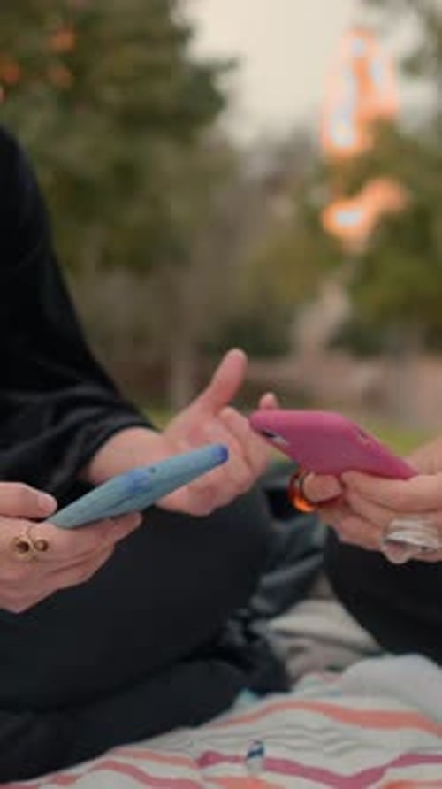 Girls in the Public Park Using Smartphones and Texting on It Close Up View