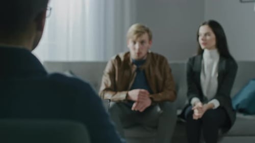 Young Couple on a Counseling Session with Psychotherapist. Back View of Therapist Taking Notes: Ang