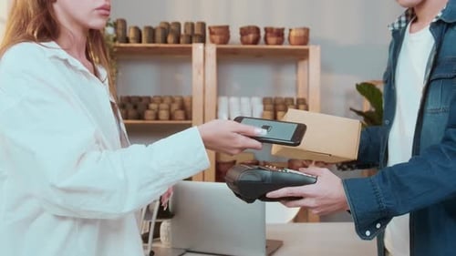 woman customer using QR code payment via smartphone for paying at shop