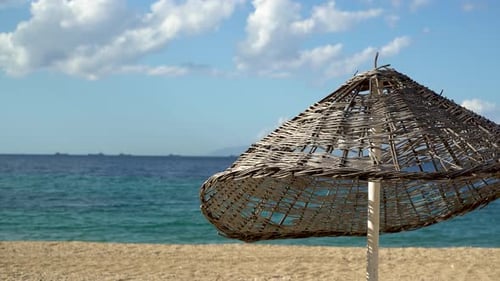 Straw Parasol and Blue Sea on the Beach 4K