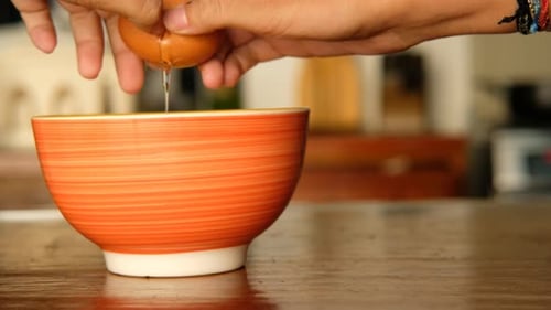 Breaking egg to bowl. baking ingredients. home cooking, close-up.