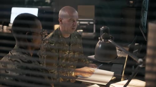 Military Personnel Reviewing Data in Dark Operations Room