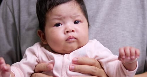 Adorable Infant Held in Parent's Arms Close Up