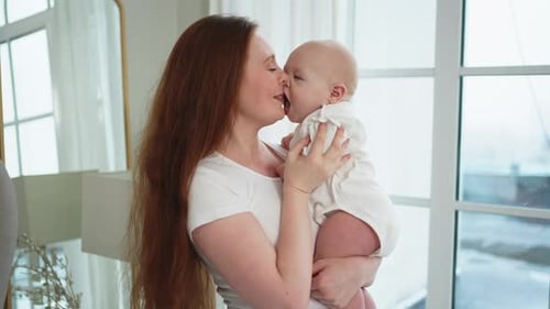 Loving Mother Embracing Her Adorable Baby Indoors