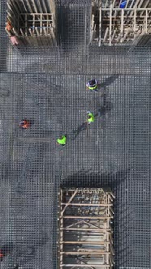 Vertical Video Workers Bend Rebar and Pour Concrete As Engineers Supervise on a HighQuality