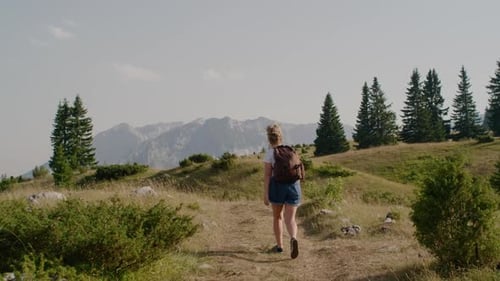 Woman Hiking on Mountain Trail with Backpack