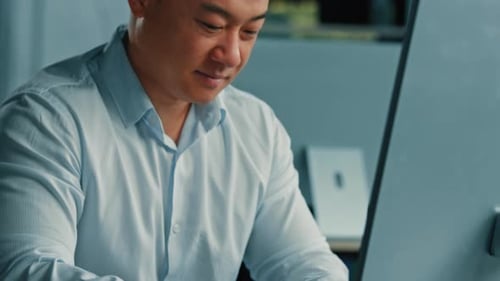 Professioneller männlicher Arbeiter Asiatischer Koreaner Erfolgreicher Geschäftsmann, Programmierer, Spezialist, sitzt im Büro