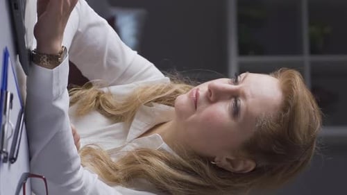 Woman Typing on Laptop in Bright Office