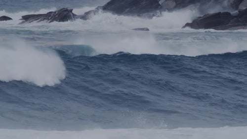 Grandes olas chocan en la costa de Sídney, con costas rocosas y aire brumoso que se arremolina debido a las olas.