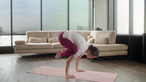 Woman Practicing Yoga at Home on a Mat