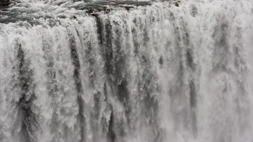 Powerful Waterfall Cascading Down Rocky Cliff in Winter